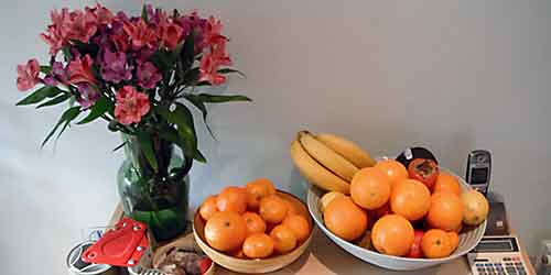 Vase, fruit bowl and other objects on a cupboad